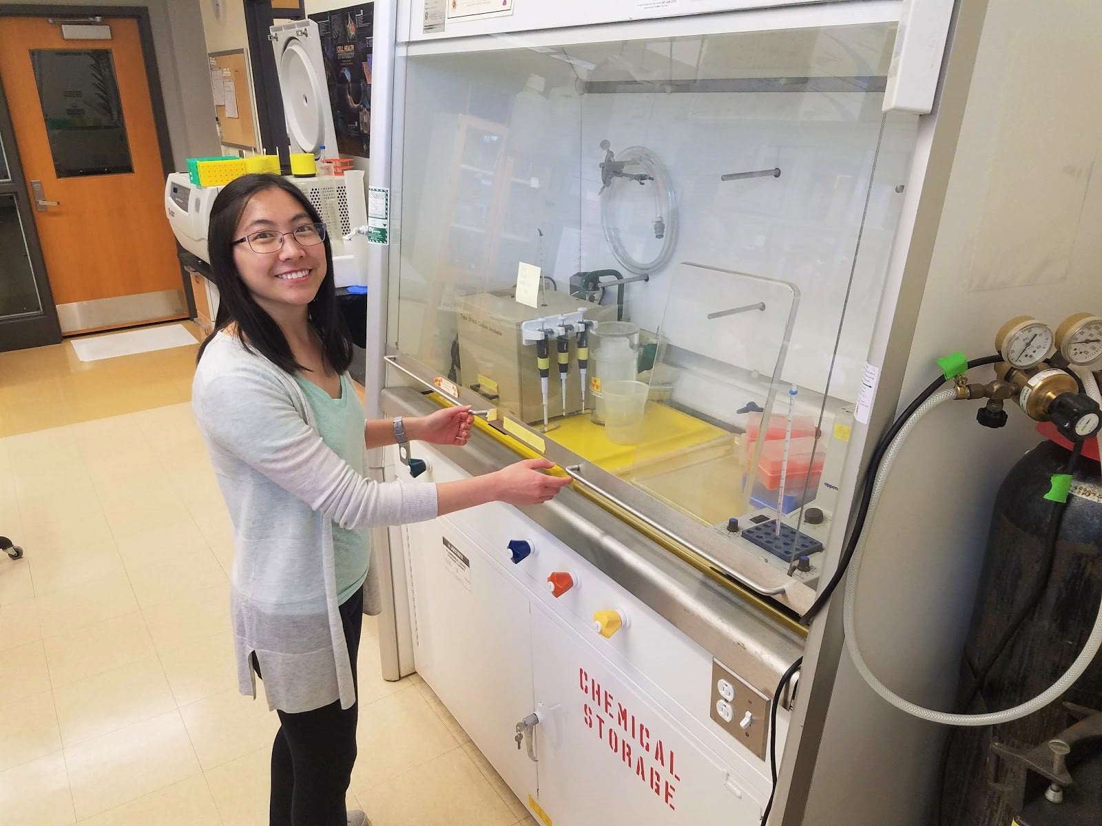 Charmaine Yuan in the Andrews lab shown shutting the sash of a fume hood