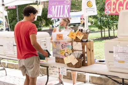 Student buying cheese at the Farmers Market