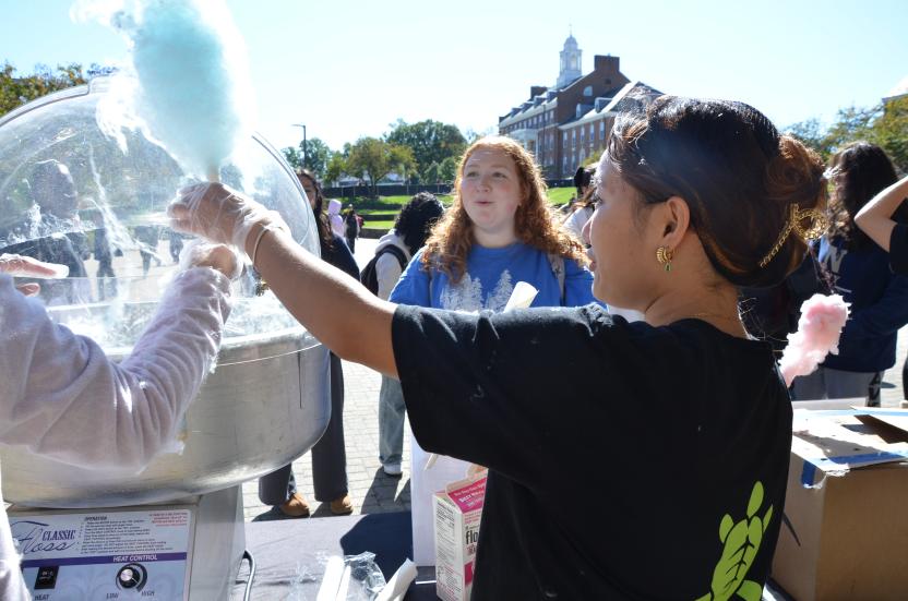 Image of an Office of Sustainability intern making blue cotton candy for a student