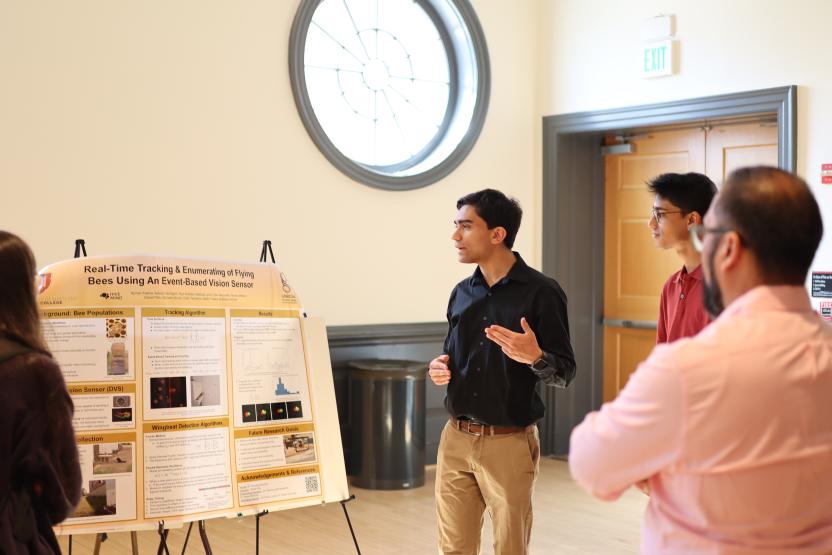 Student presenting next to his poster about Pollinator Biodiversity