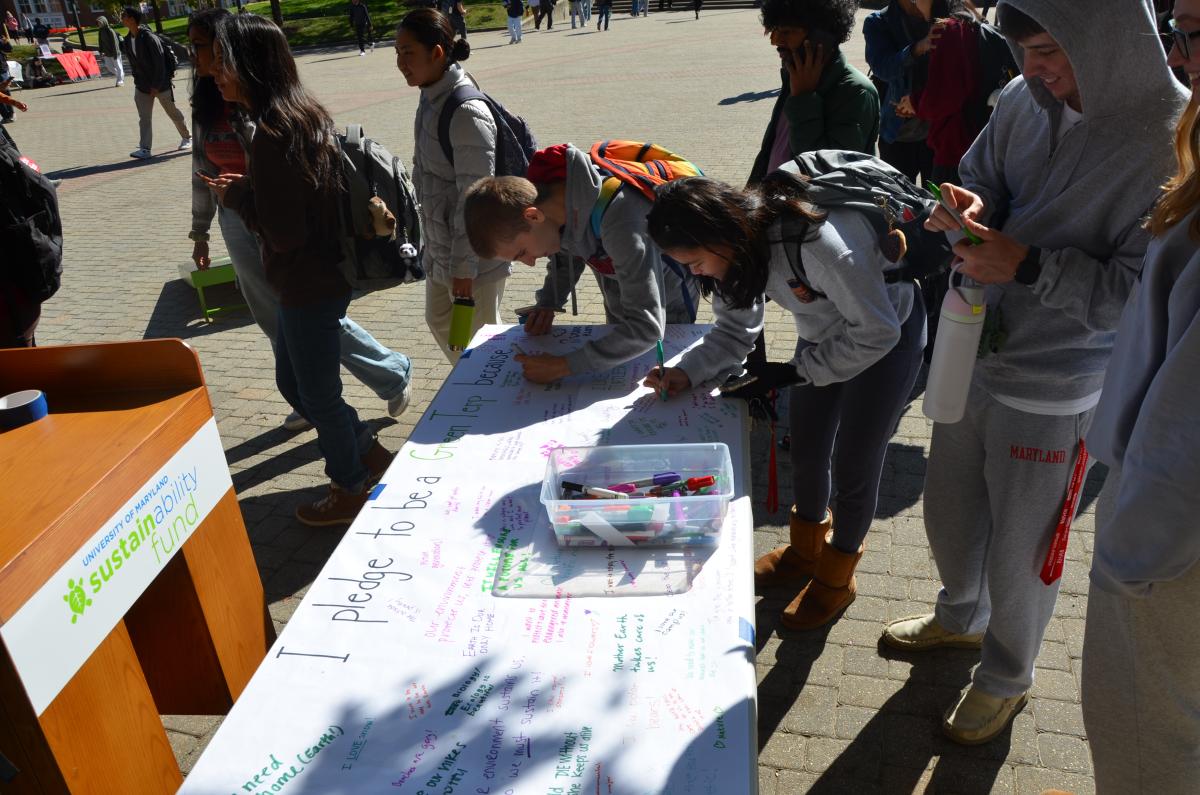 Image of two students writing a pledge as to how they will be a Green Terp