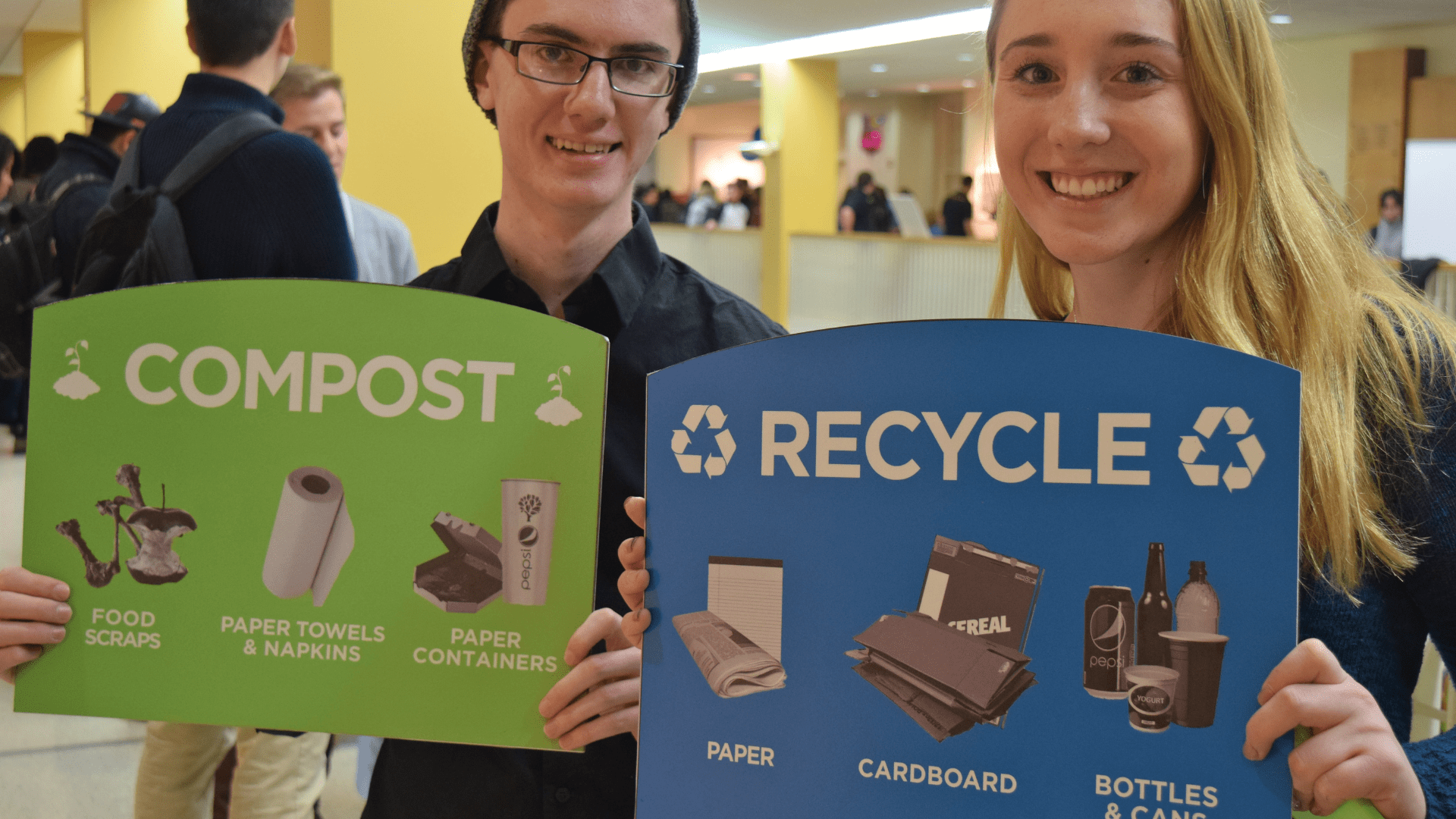 People Holding up compost & recycling signage