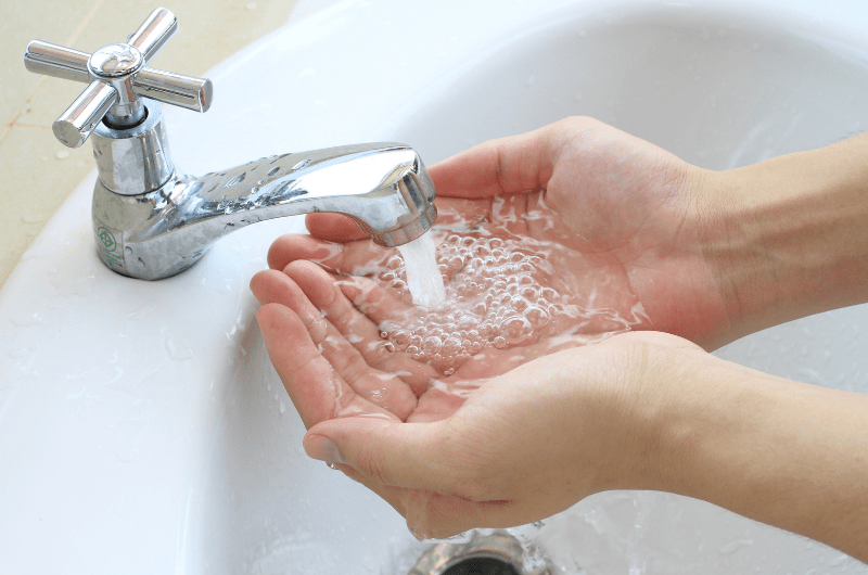 Person using sink, hands under water
