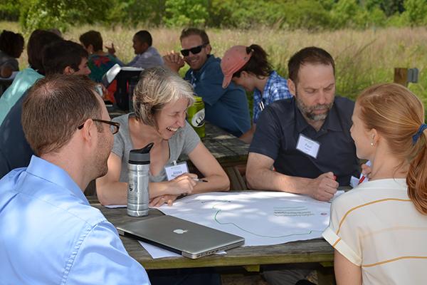 Teaching fellows talking and laughing, seated outdoors