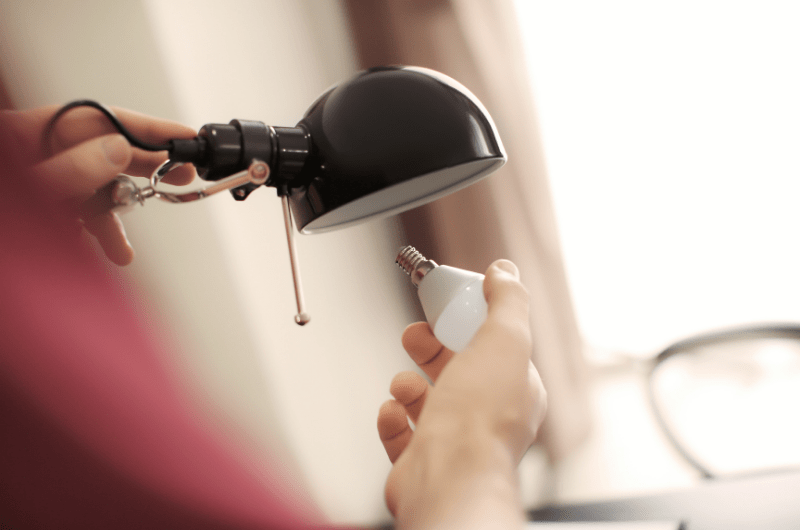 Hand installing a light bulb