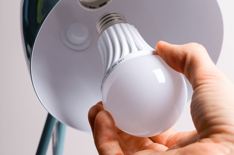 Hand installing a light bulb