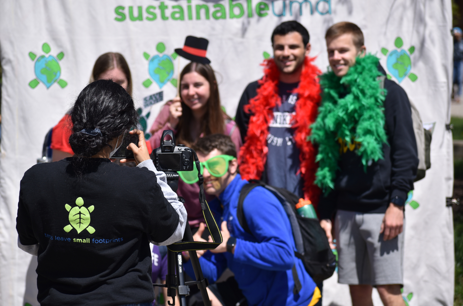 Students at Photo Booth, sustainableUMD logo