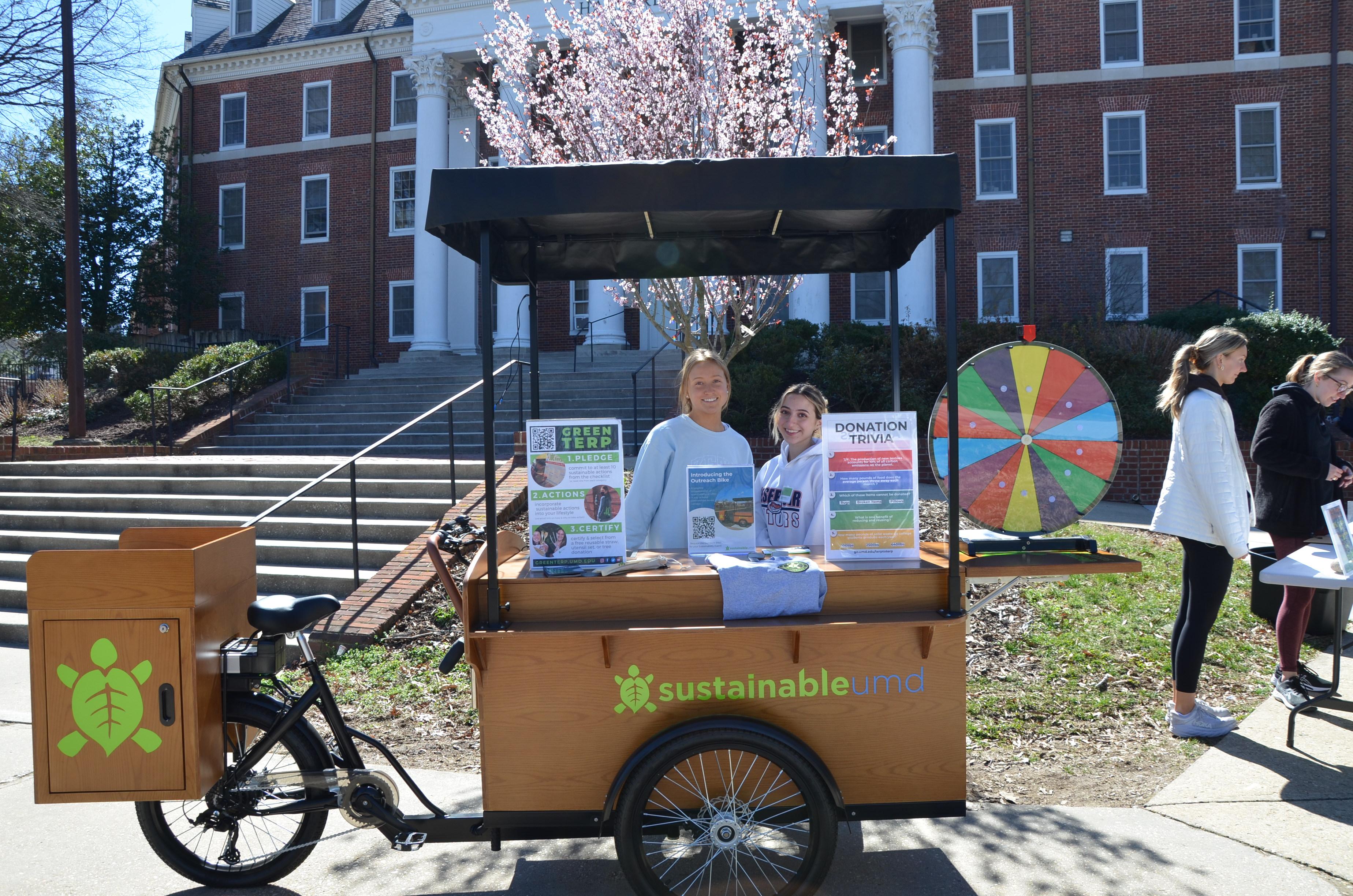 OS intern and ambassador standing at the Outreach Bike