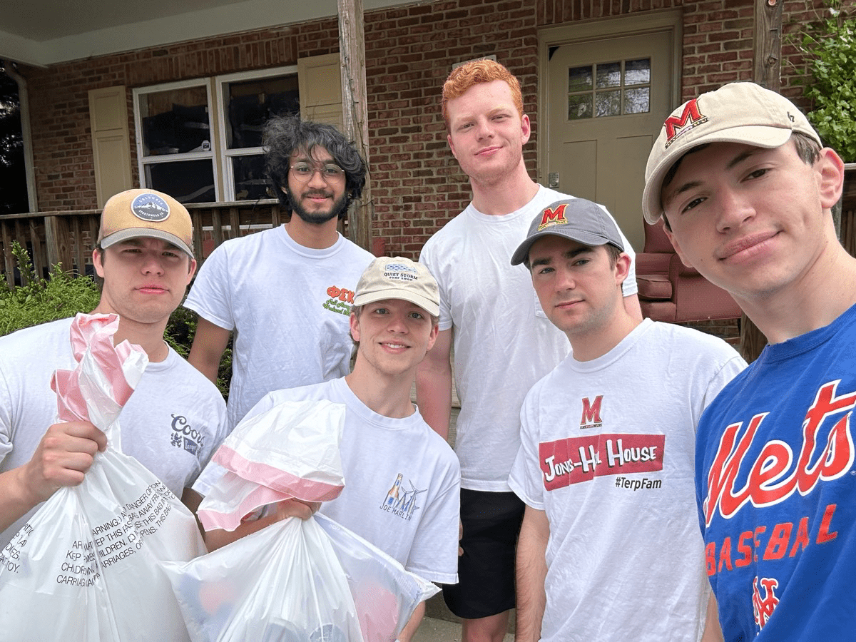 Group of students holding trash bag of litter