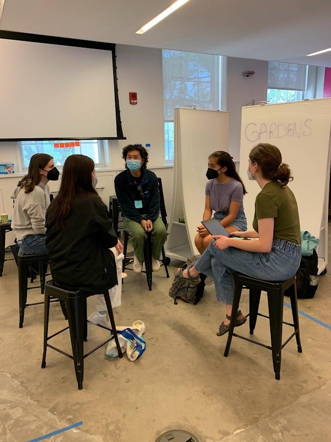 group of students sit and discuss gardens