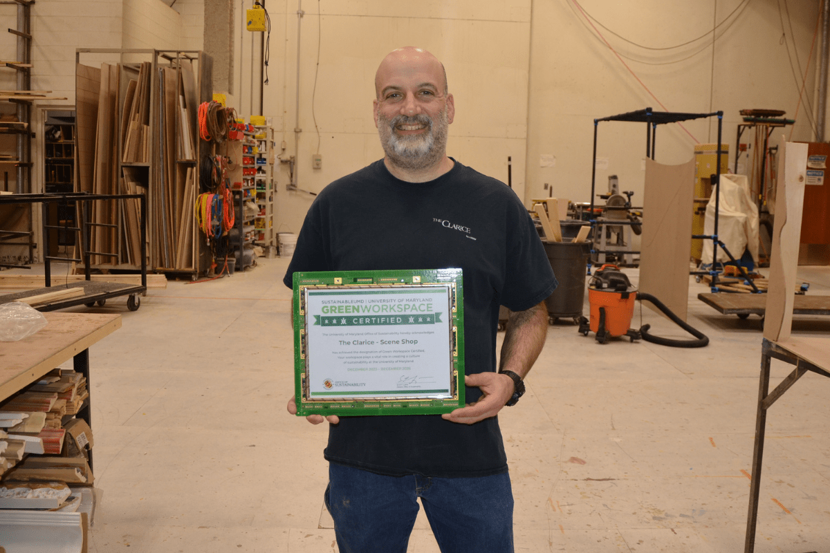 Staff (Reuven) holding framed Green Workspace certificate