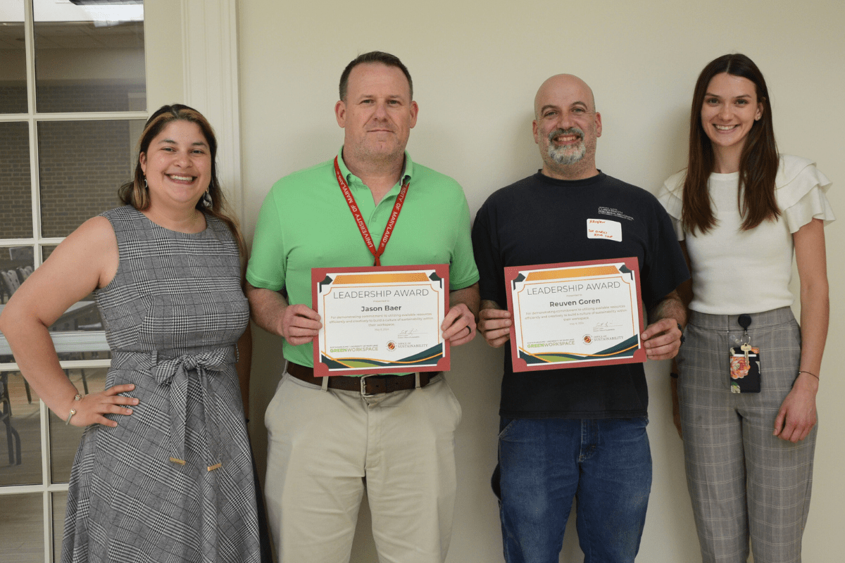 Four staff, two holding certificates