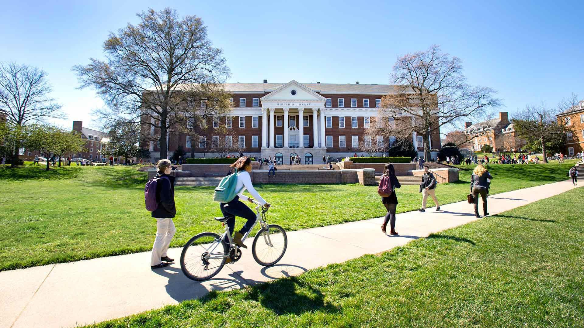 Student biking in front of McKeldin