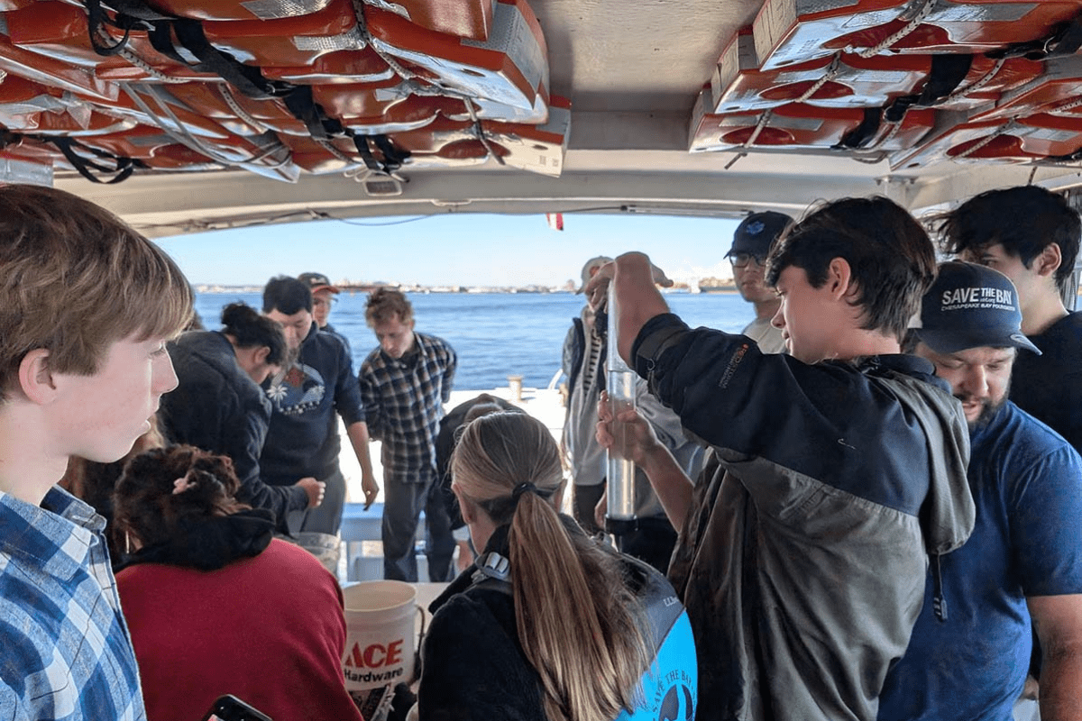 Students on boat sample and test water; view of Chesapeake Bay