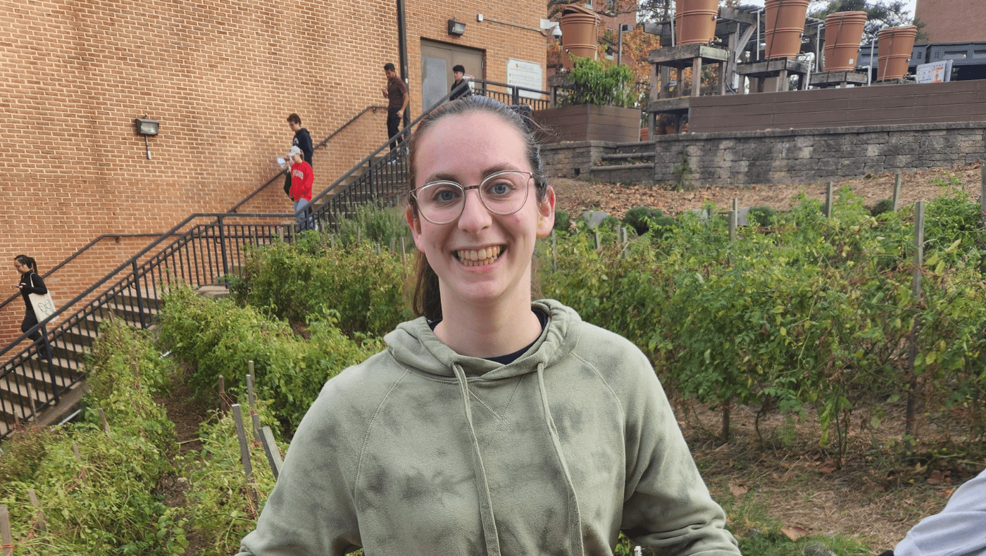 student posing for a picture in the Community Learning Garden