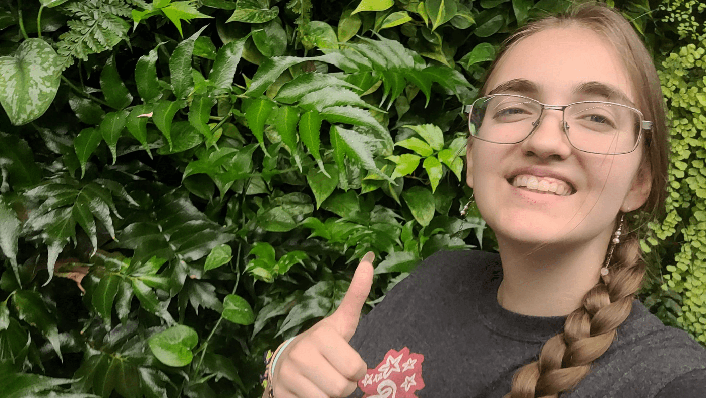 student posing in front of a biowall