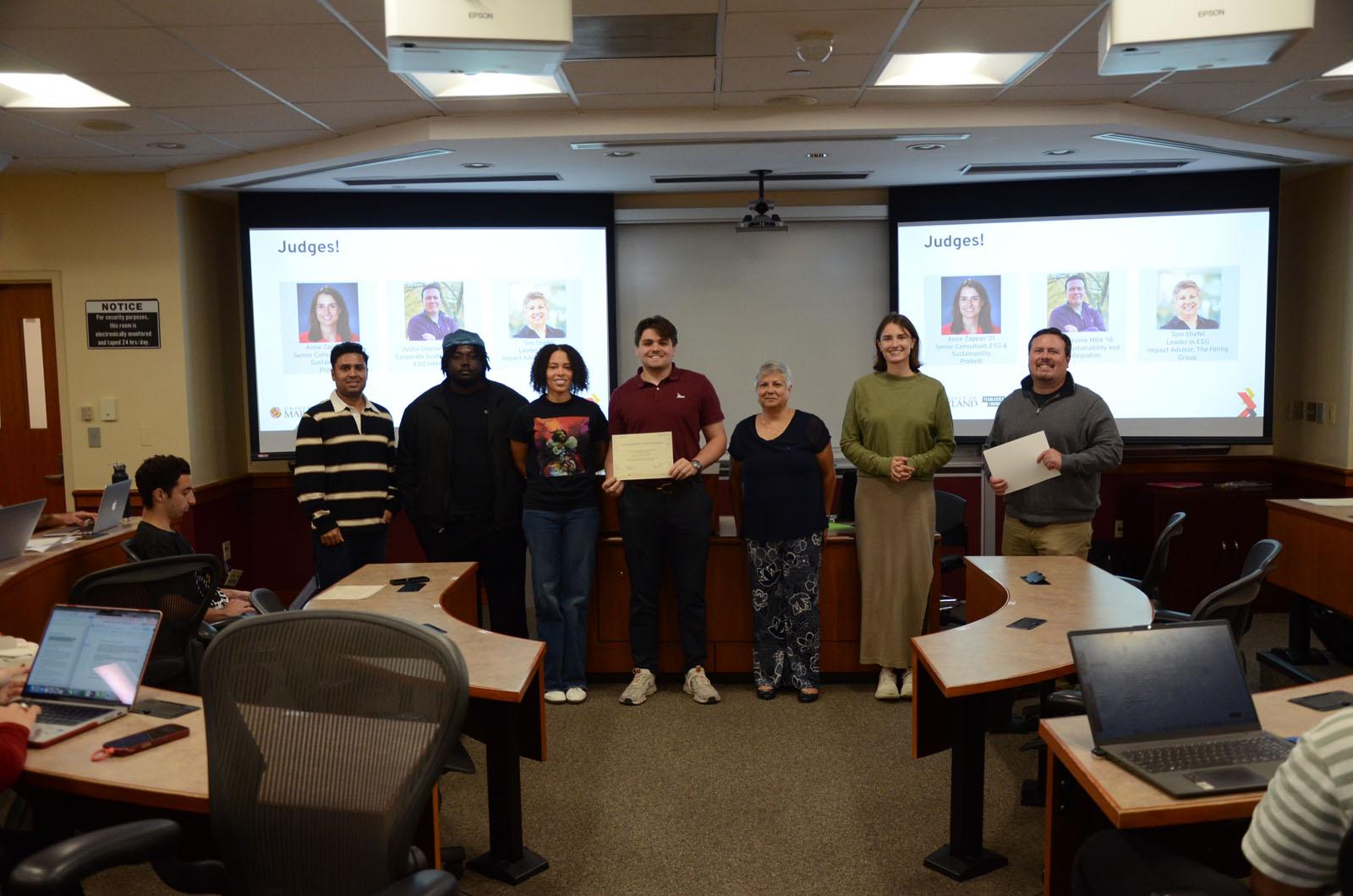 Students smiling with judges during award presentation