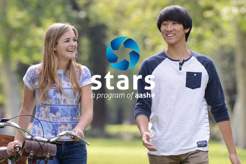 Students walking outside with trees in the background