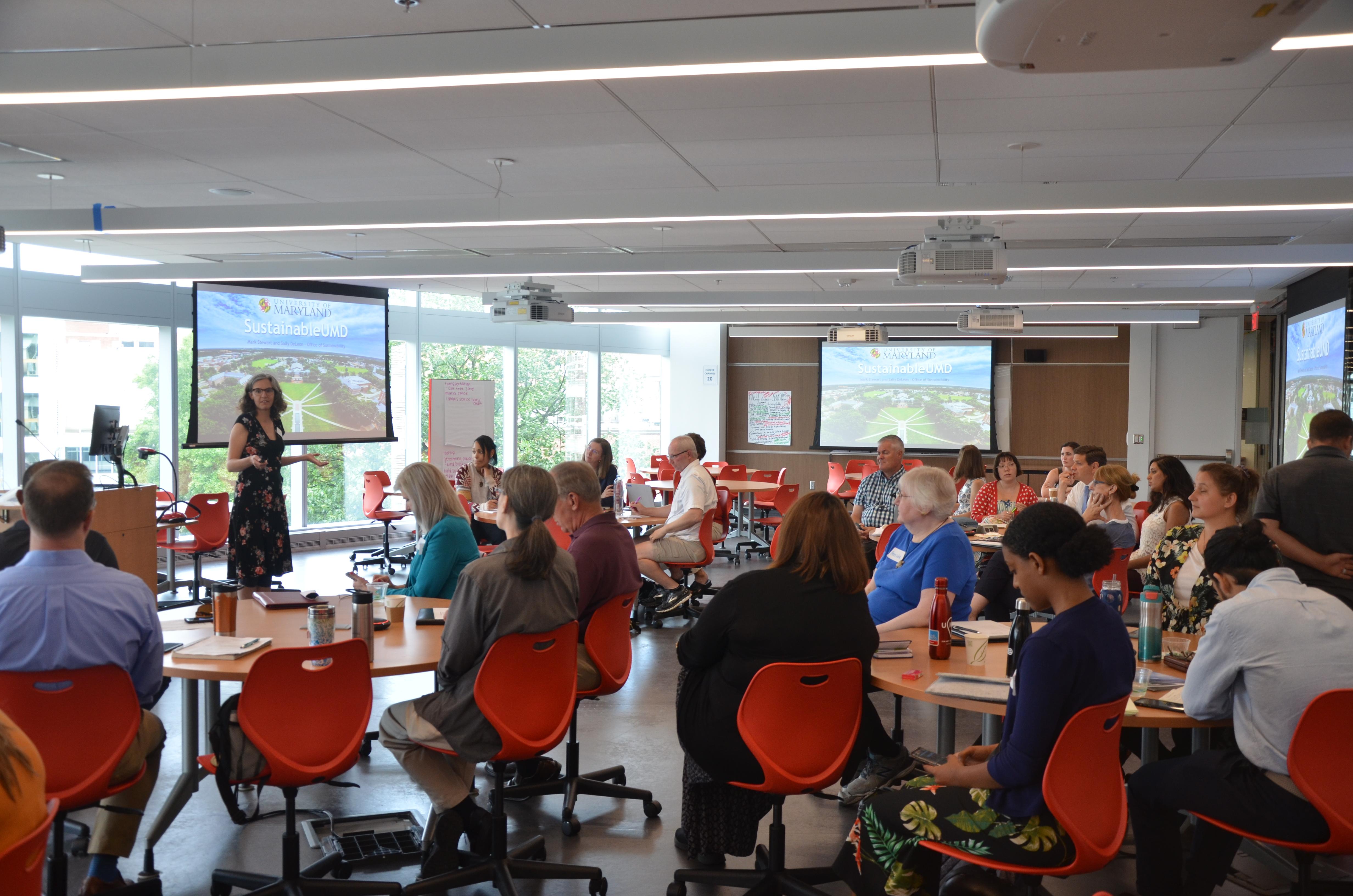 Group of staff and faculty listening to a presenter talk about sustainability